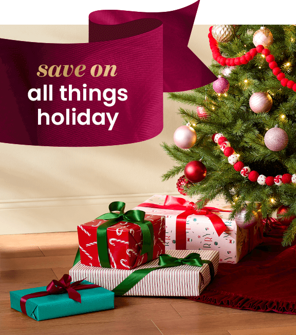 Gifts wrapped in patterned wrapping paper, tied with velvet bows, under artificial Christmas tree